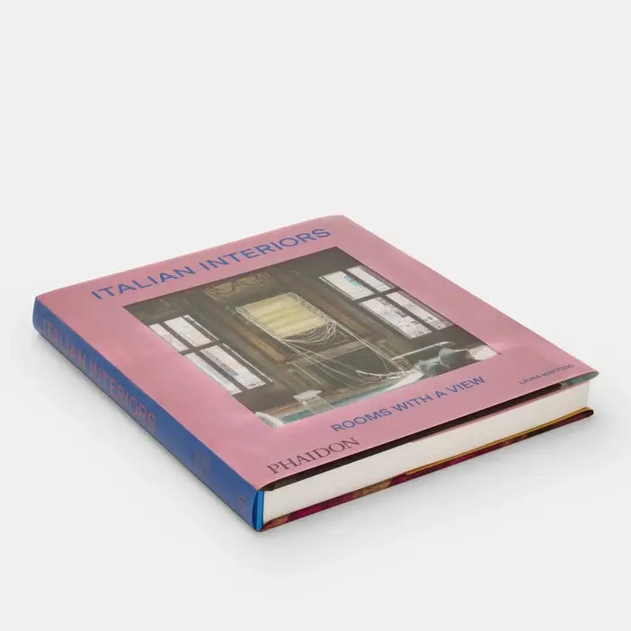 Cover image of Italian Interiors: Rooms With A View by Phaidon, showcasing a beautifully designed interior space with large windows and elegant decor.