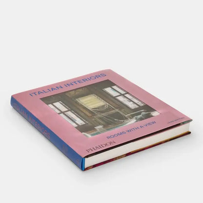 Cover image of Italian Interiors: Rooms With A View by Phaidon, showcasing a beautifully designed interior space with large windows and elegant decor.