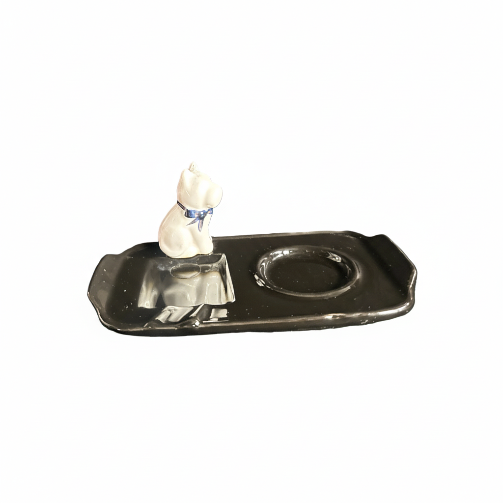 Small white figurine on a metallic surface ashtray