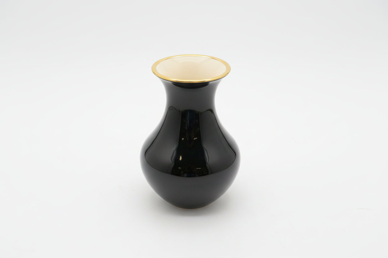 Black vase with gold rim on a white background