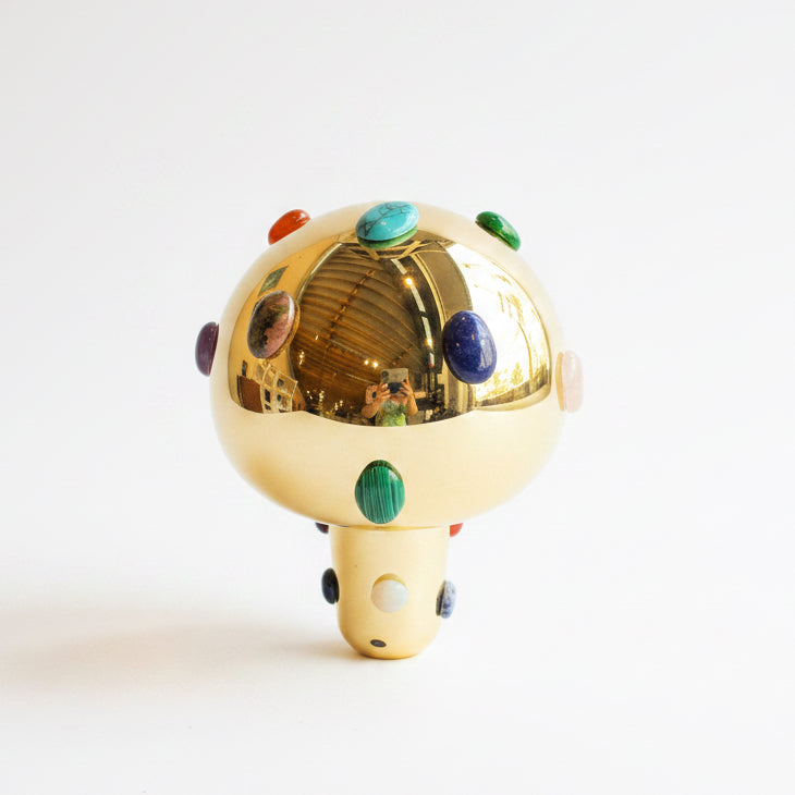 P. Grunsfeld Stoner Brass Wireless Lamp by The Vault Creative with sleek brass finish and modern design, illuminated on a wooden surface.