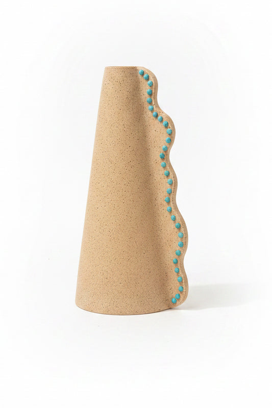 Ceramic wavy vase by P. Grunsfeld from The Vault Creative, featuring a textured surface and flowing wave design in neutral tones.