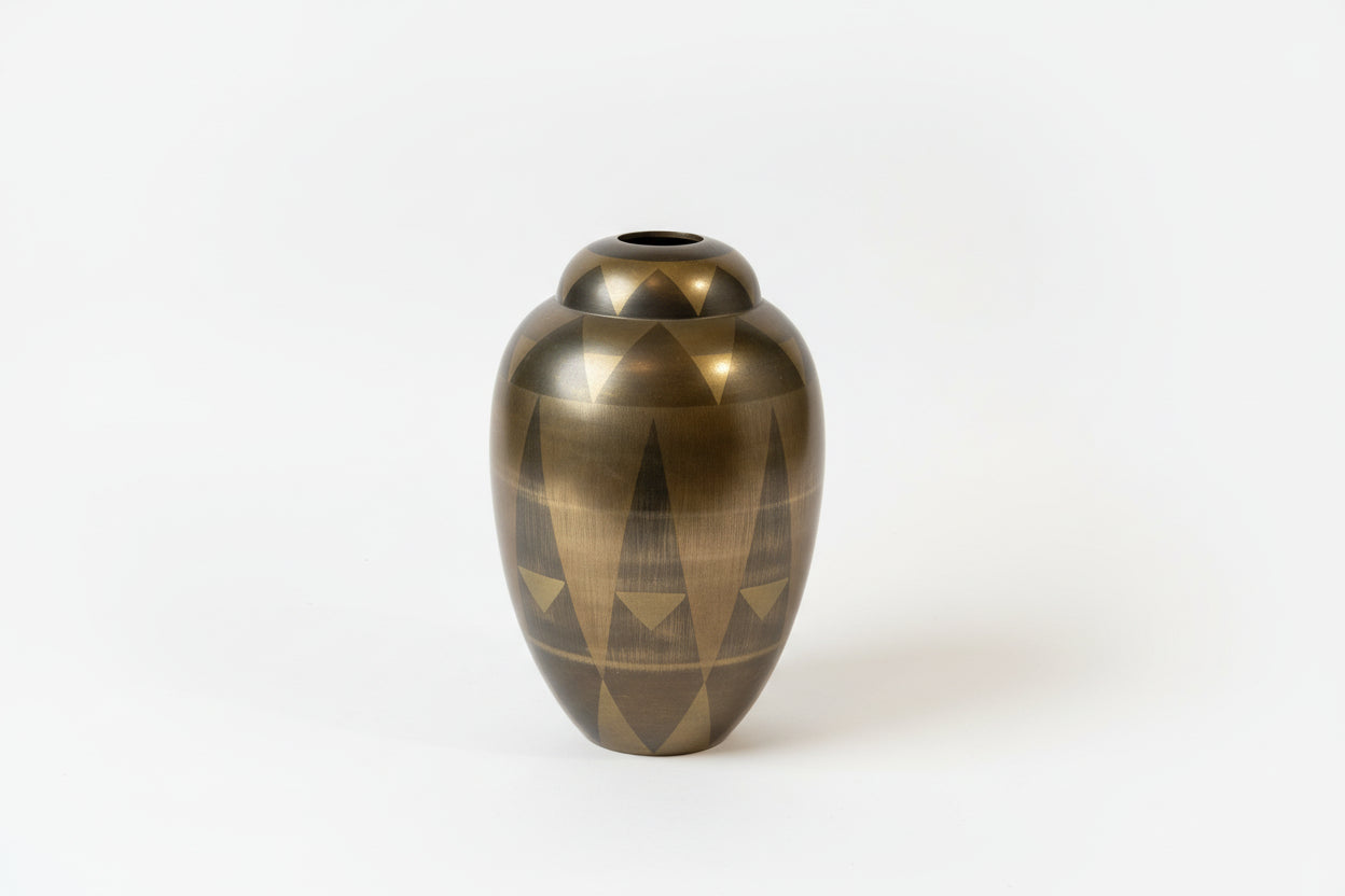 Bronze vase with geometric design on a white background