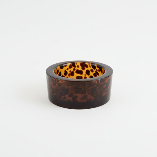 Round, dark-colored object on a textured 